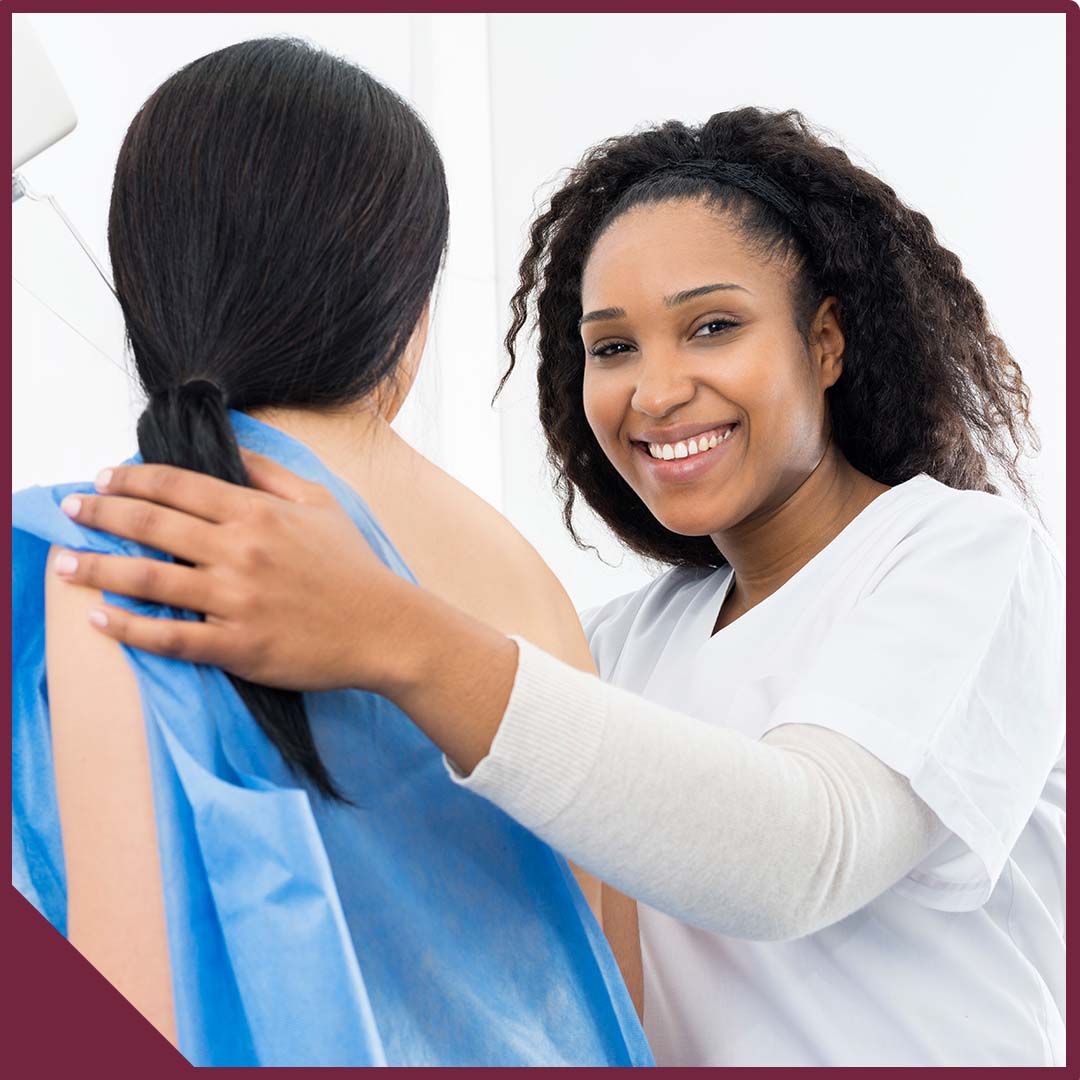 Image-3 (1) A female patient in a gown with her back turned and a smiling doctor looking at the camera.
