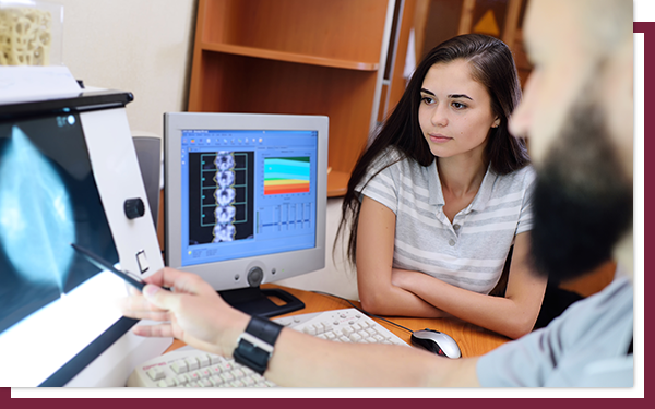 What Do They Look For in a Breast Ultrasound - IMG 3 A radiologist showing a young patient an ultrasound view of her breast.