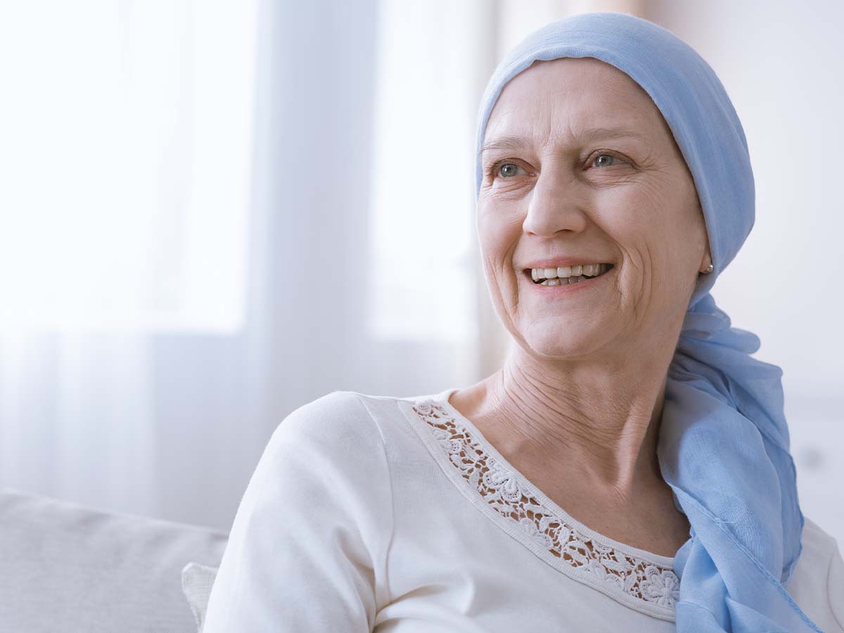 1200x900GMB-3 An older woman wearing wrap on her head and smiling from the hospital bed.