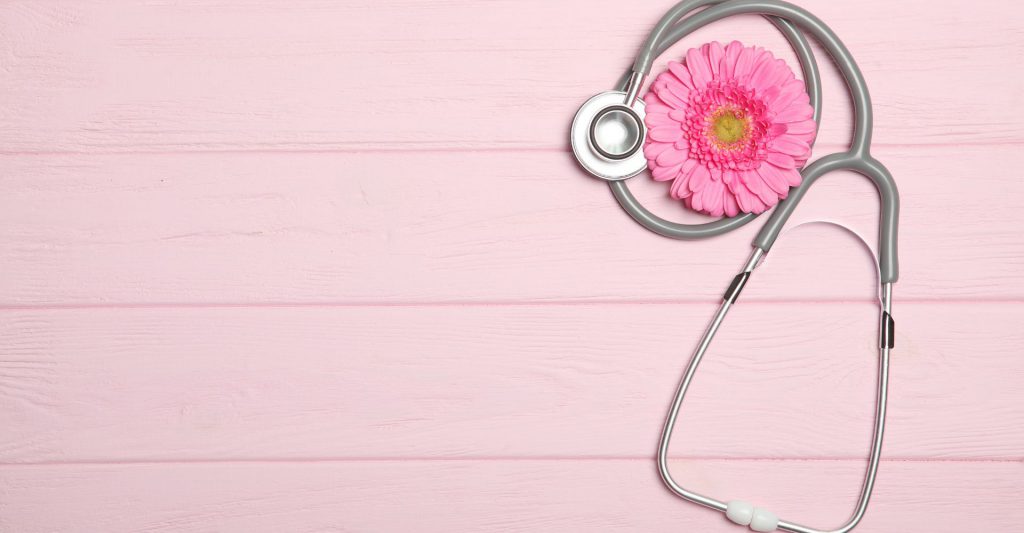 A pink background with a flower and a stethoscope.